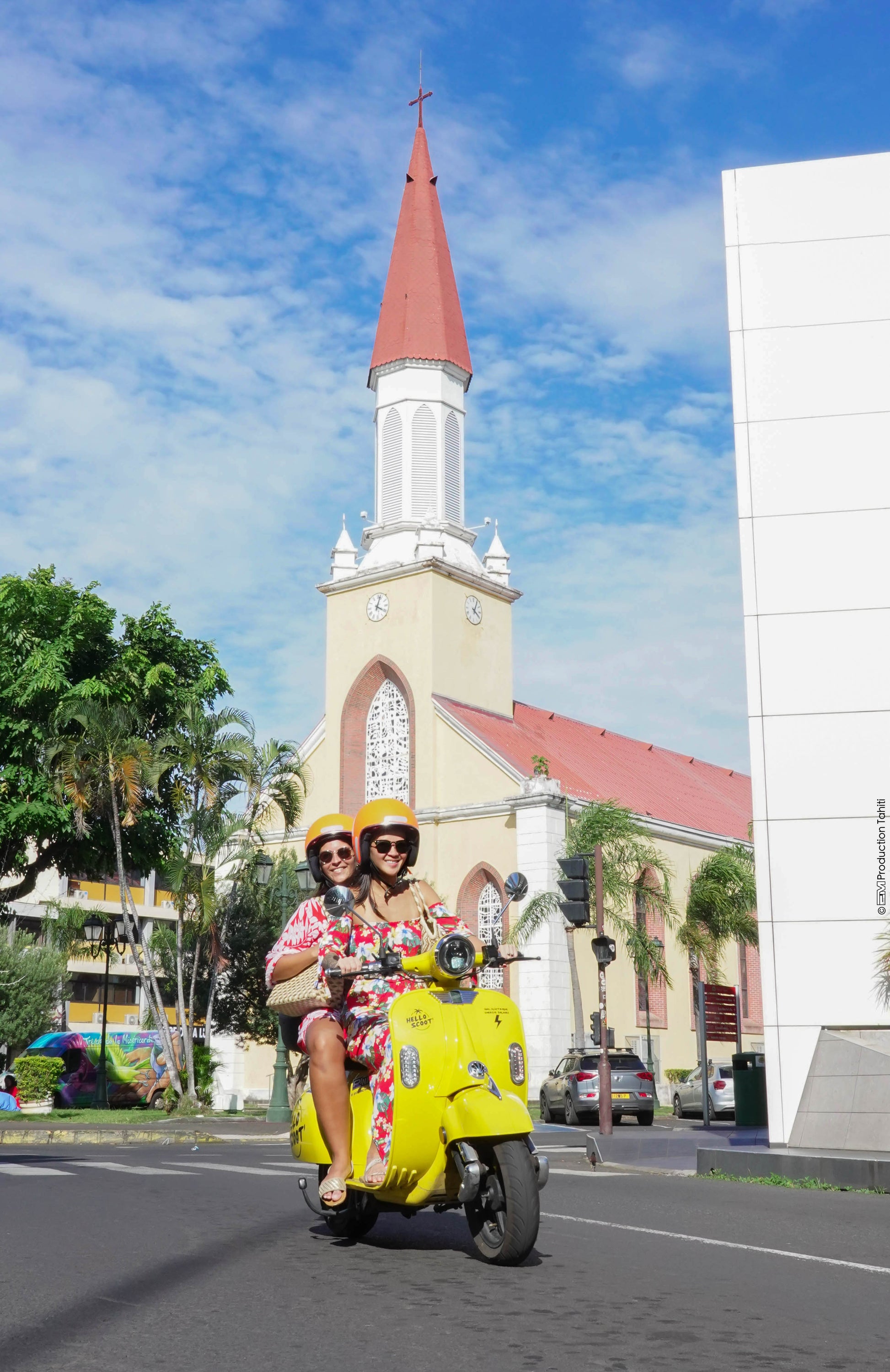 2 tahitiennes roulent en Hello Scoot' scooter de location devant la cathédrale de papeete à Tahiti